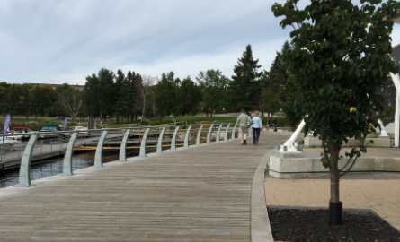 two people walking arm in arm on board walk along harbourfront